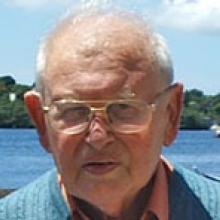 homem branco, de óculos de grau, cabelo branco e blusa azul.
